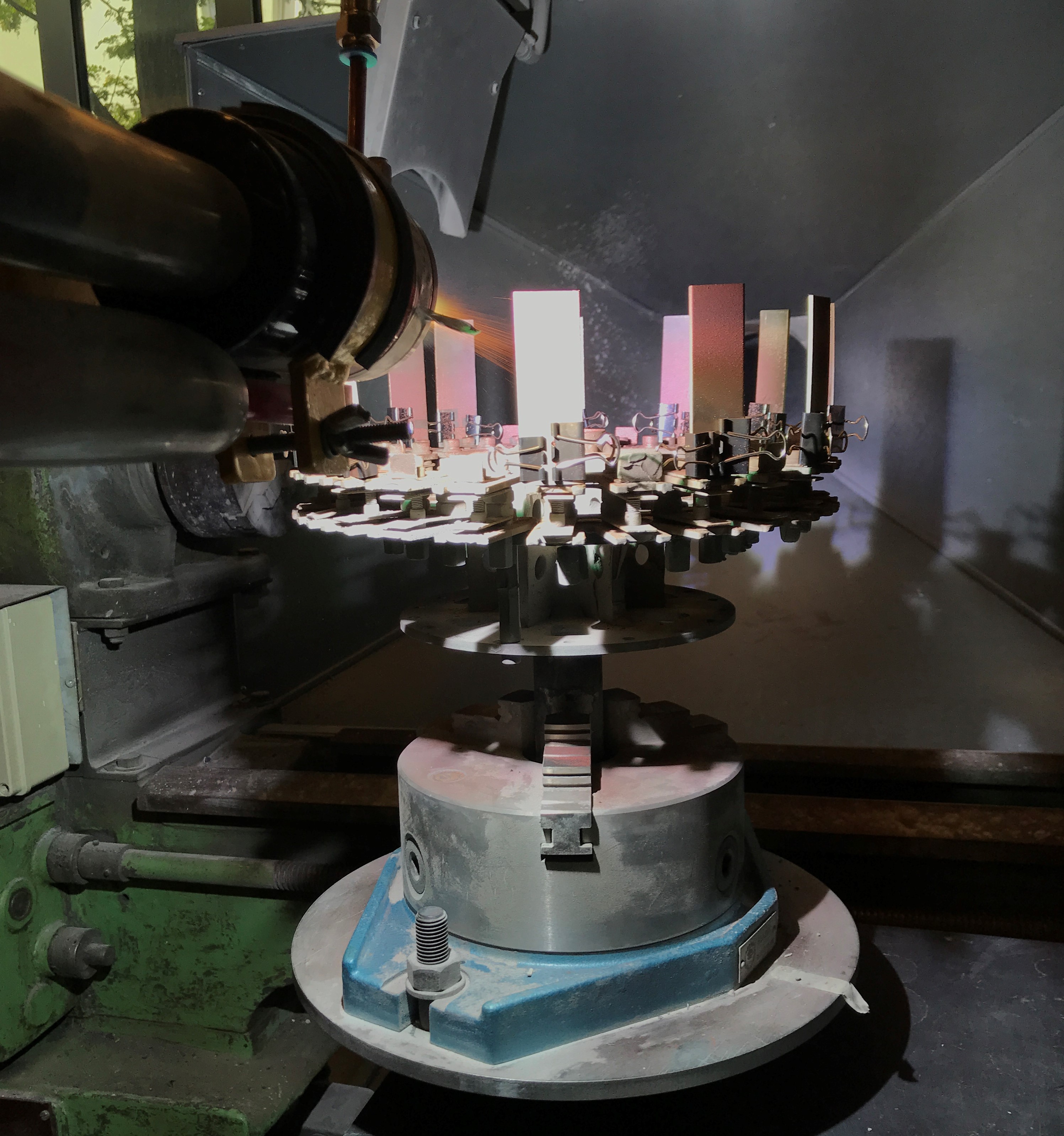 Plasmaspritzstrahl trifft im Labor auf kleine metallische Proben.